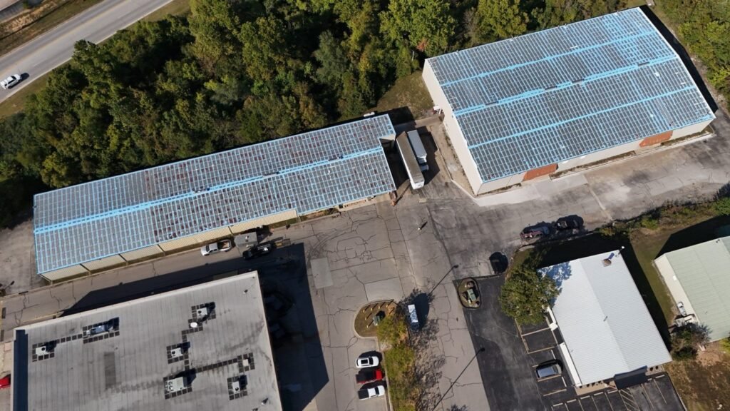 Aerial view of two Hollister, MO industrial warehouses with seams and fasteners prepped before roof coating